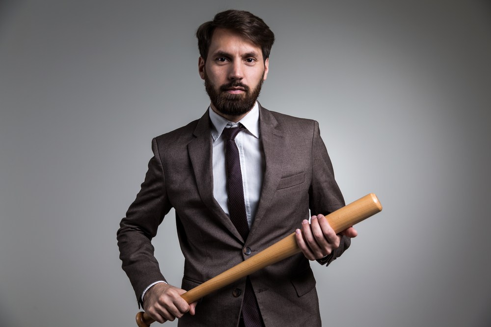 Businessman with bat symbolizing weaponized feedback